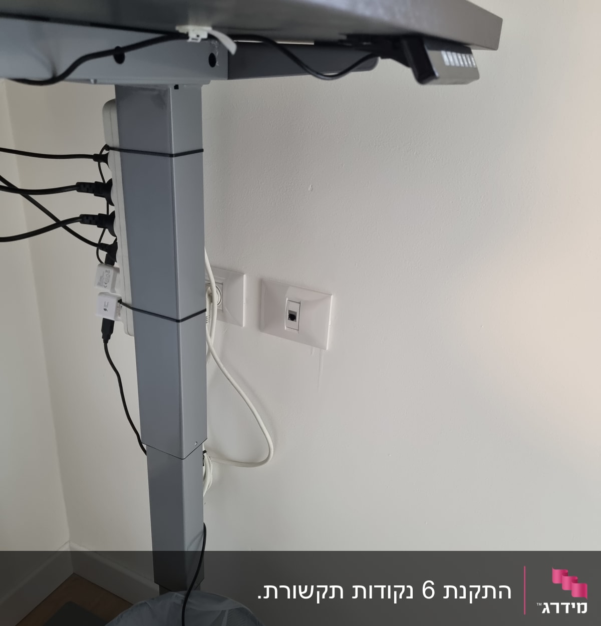 שולחן עבודה עם כבלים מחוברים לשקעי חשמל